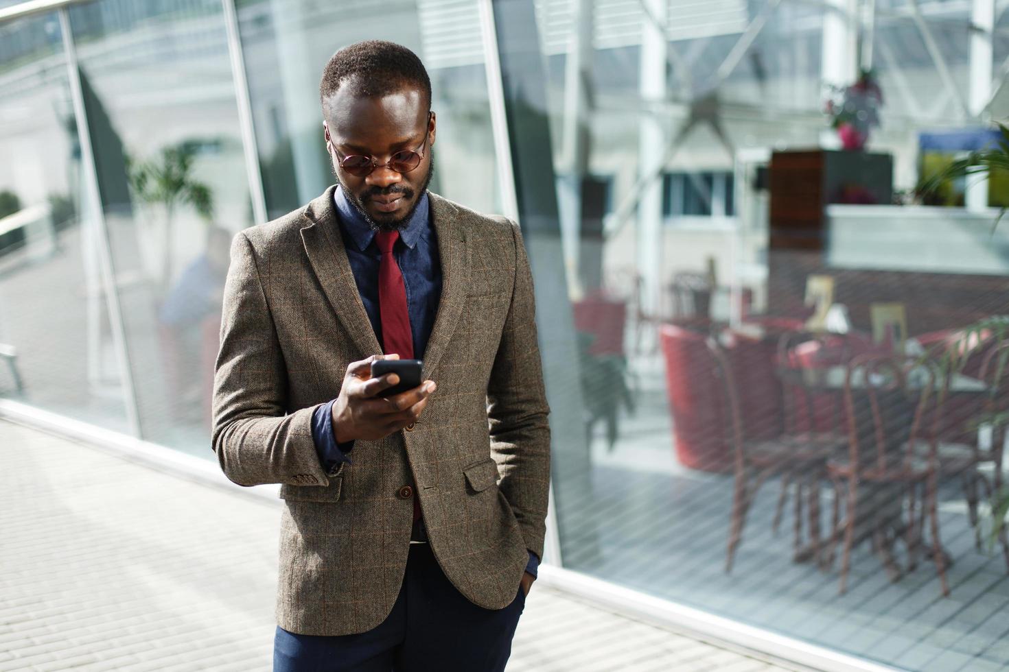 elegante empresário negro americano africano trabalha em seu smartphone foto