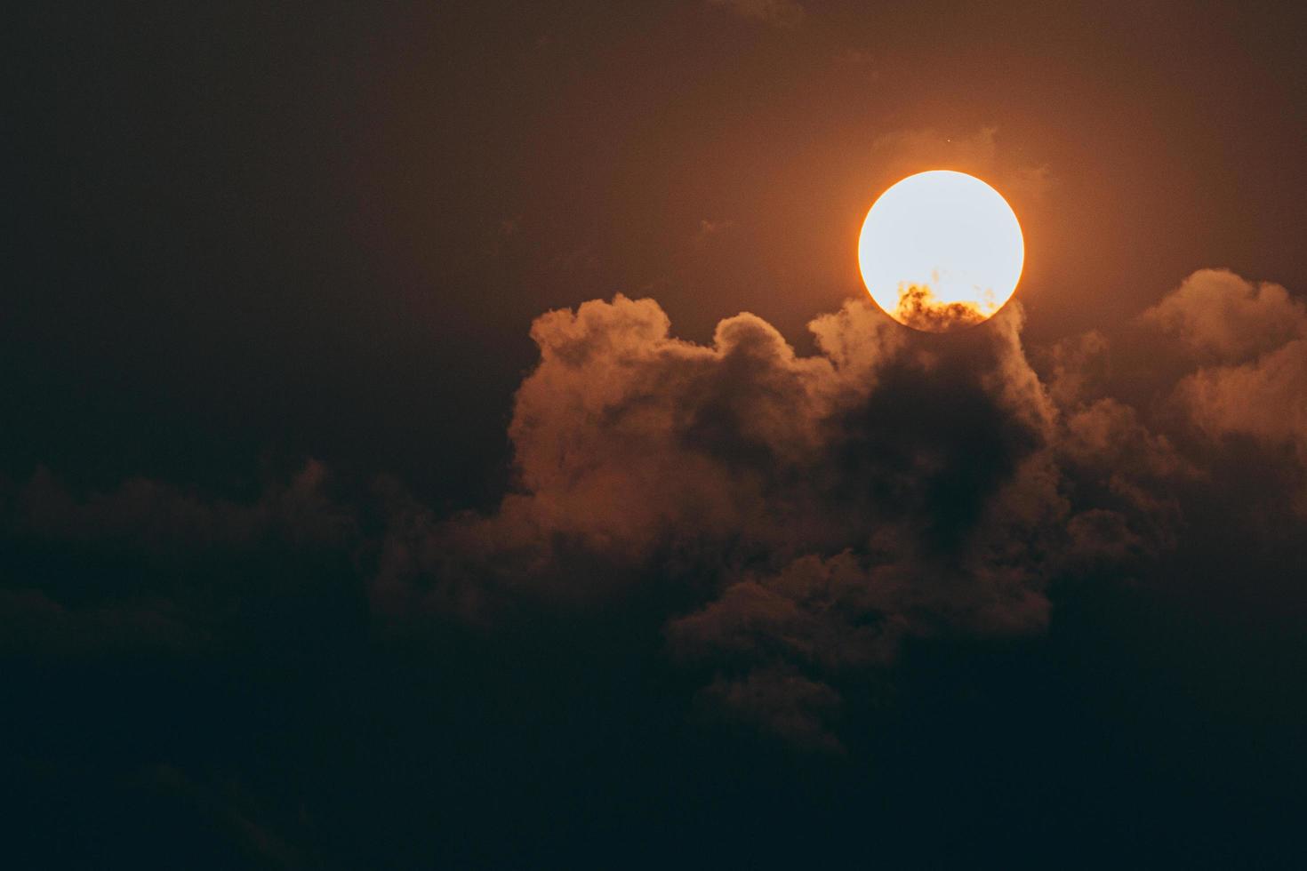 sol atrás de nuvens escuras foto