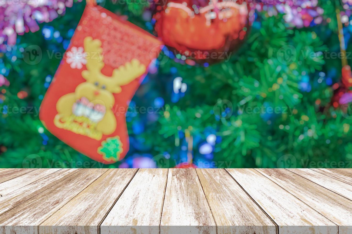 tampo de mesa de madeira vazio com árvore de natal desfocada com fundo claro bokeh foto