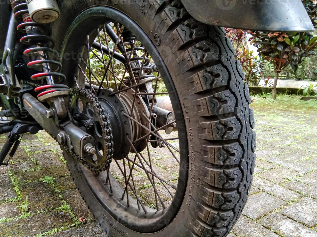a roda traseira de uma moto estacionada no quintal foto