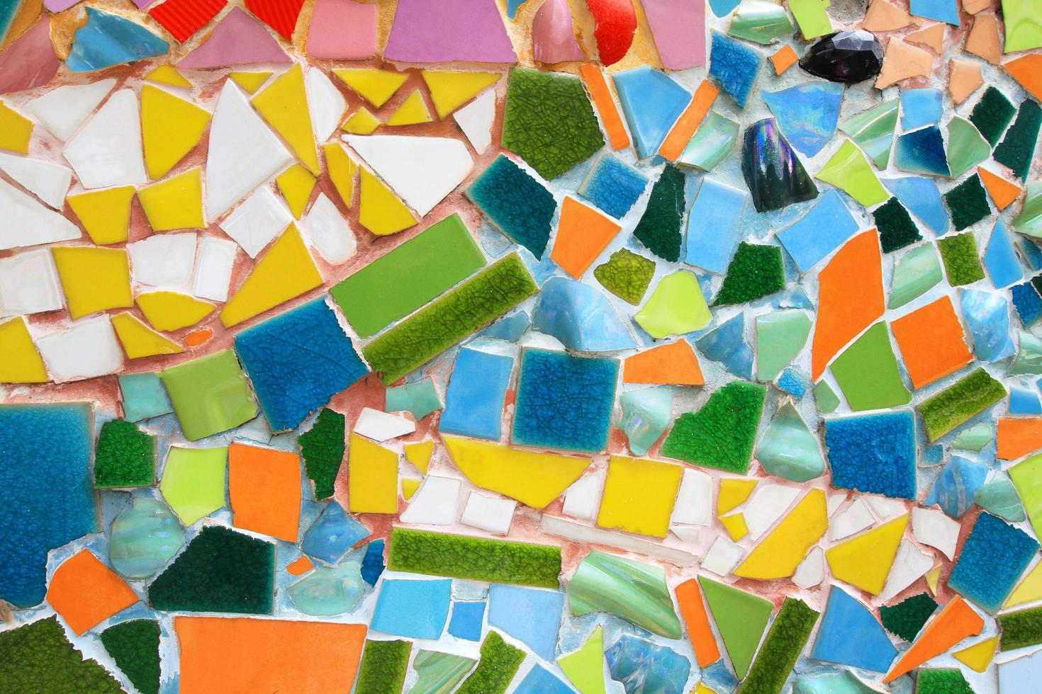 tailândia-22 de fevereiro de 2021 colorido de fundo de mosaico. papel de parede de design de arte, rachado, forma e resumo. fragmentos de azulejo verde, amarelo, azul, branco e laranja na parede. foto