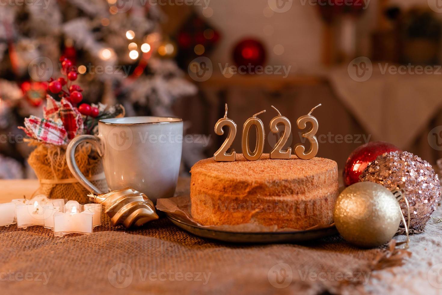 bolo de mel caseiro na cozinha com velas 2023. ano novo aconchegante em casa. Feliz Natal. foto de alta qualidade