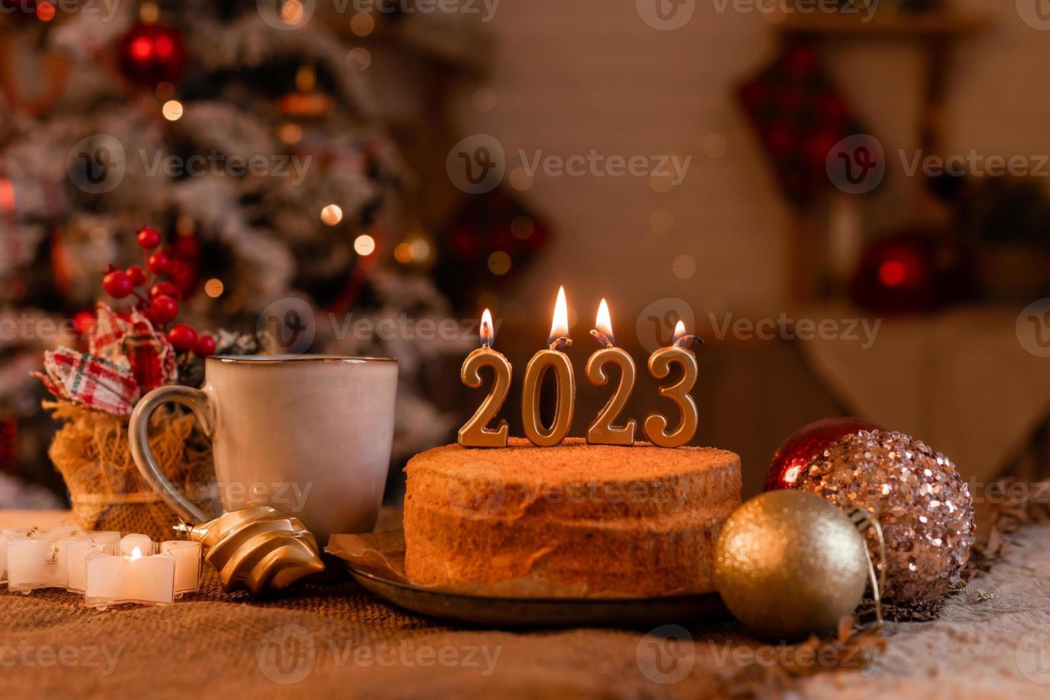 bolo de mel caseiro na cozinha com velas 2023. ano novo aconchegante em casa. Feliz Natal. foto de alta qualidade