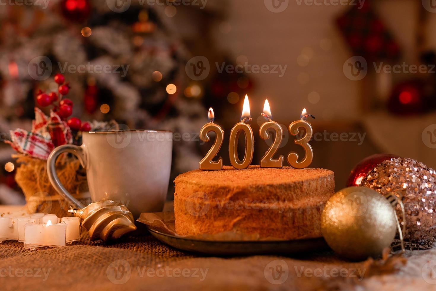 bolo de mel caseiro na cozinha com velas 2023. ano novo aconchegante em casa. Feliz Natal. foto de alta qualidade