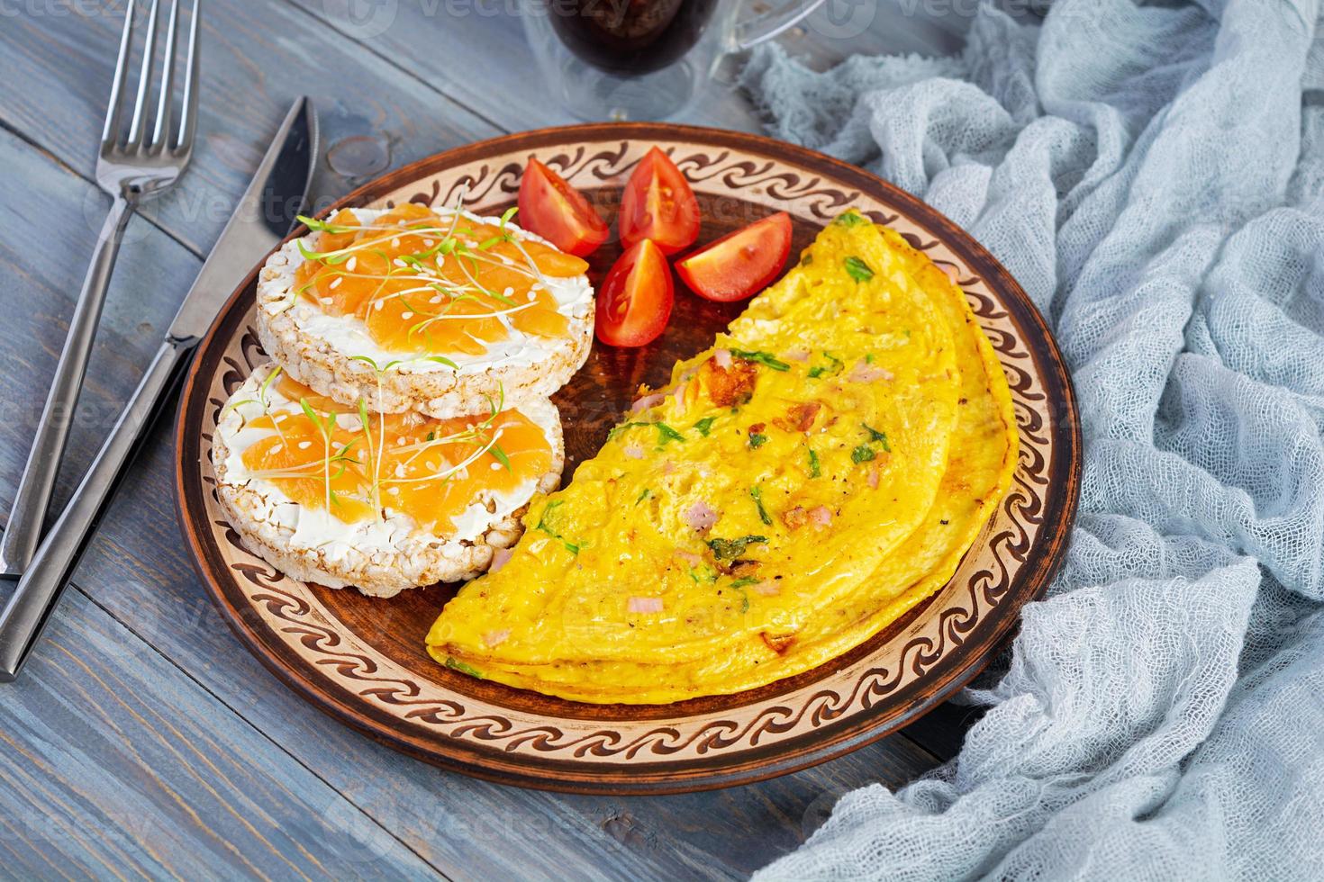 omelete frito com carne e ervas. delicioso café da manhã com ovos, bolos de arroz tufado e salmão foto