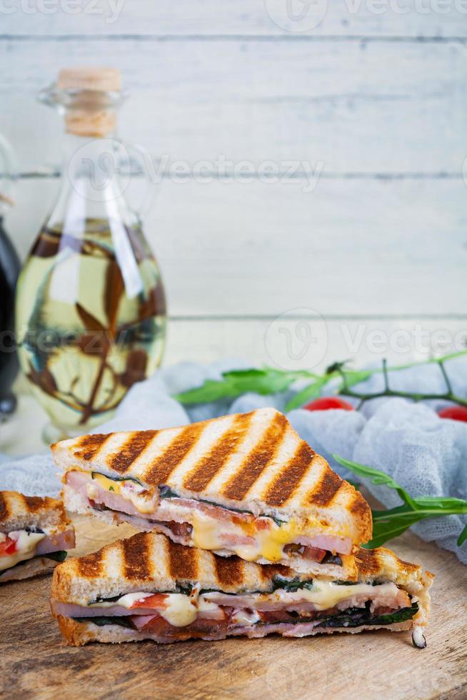 sanduíche com presunto, queijo, folhas de mostarda, tomate e cebola. saborosos sanduíches grelhados foto