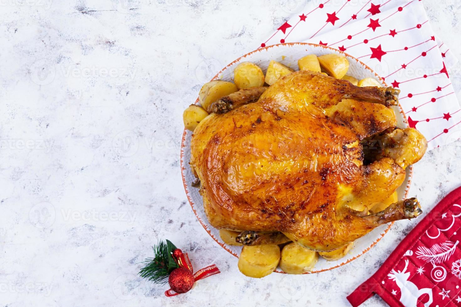 frango assado e batata com decoração de natal. comida tradicional para o natal ou dia de ação de graças foto