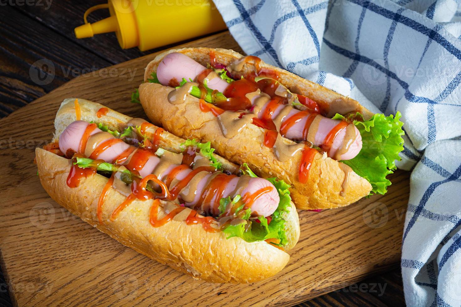 delicioso cachorro-quente com ketchup e mostarda em fundo de madeira. comida de rua foto