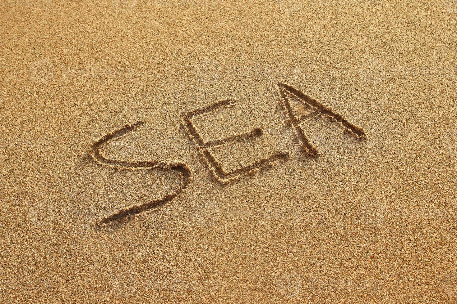 inscrição em uma areia molhada - mar - em um pôr do sol, vista superior. foto