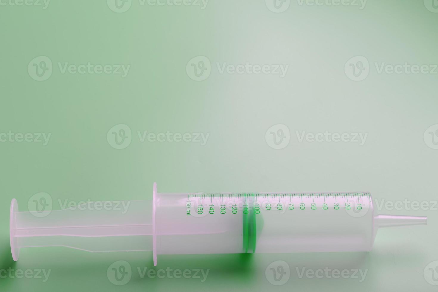 seringa médica em um close-up de fundo verde, copie o espaço. o conceito de minimalismo. foto