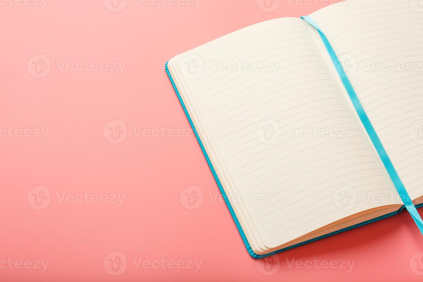 abra um laptop com páginas em branco em um fundo rosa. vista superior, copie o espaço foto