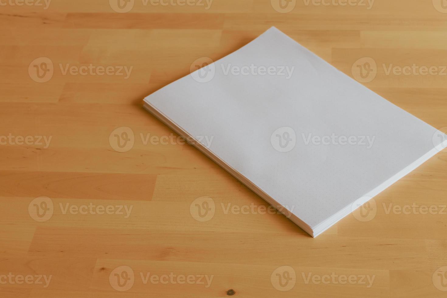 pilha de folhas de papel em branco na mesa de escritório de madeira brilhante foto
