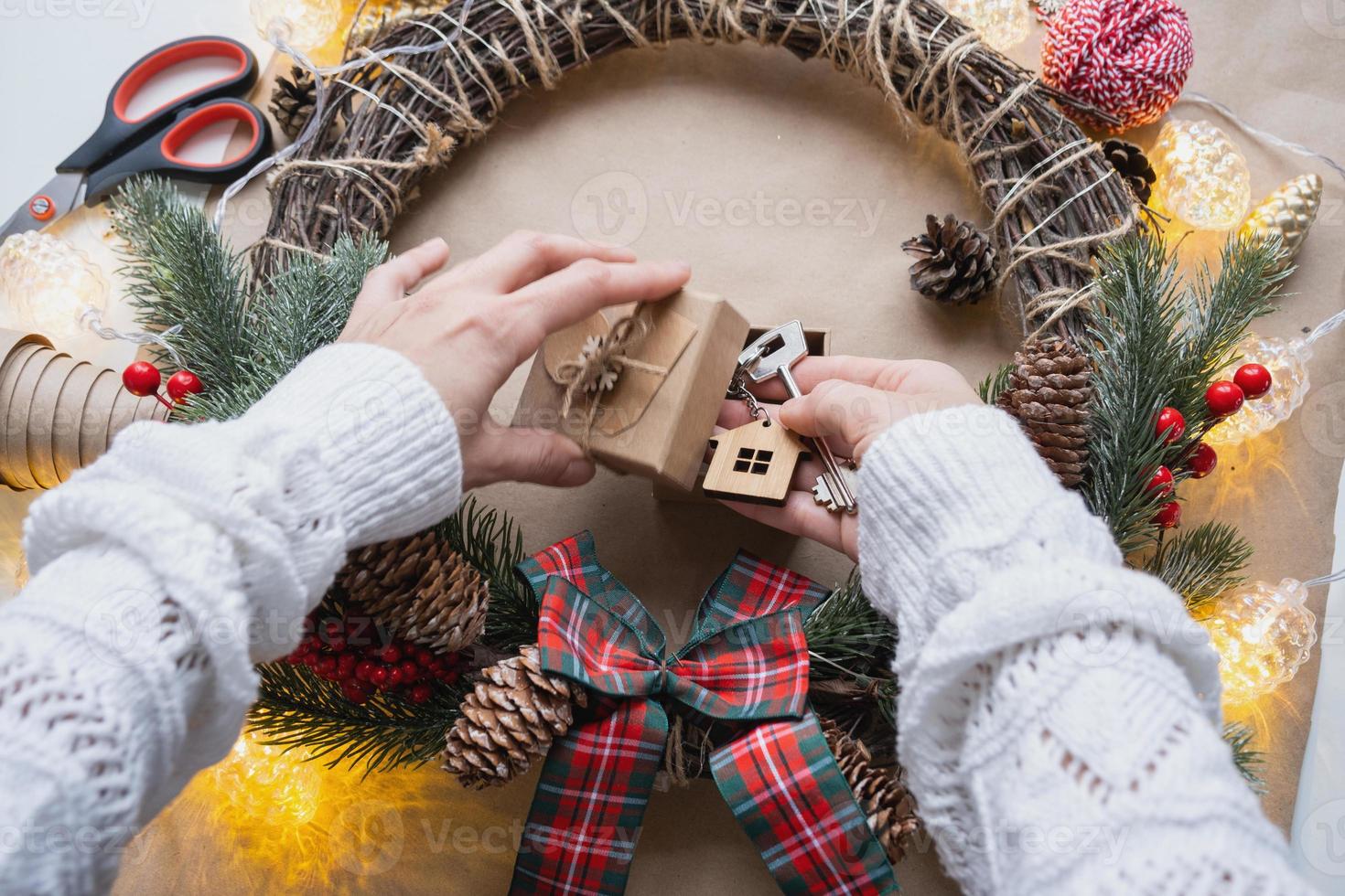 chave para casa com chaveiro em casa aconchegante em caixa de presente com embalagem de decoração de natal. embalar presente para o ano novo, natal. construção, projeto, mudança para casa nova, hipoteca, aluguel, compra de imóveis foto