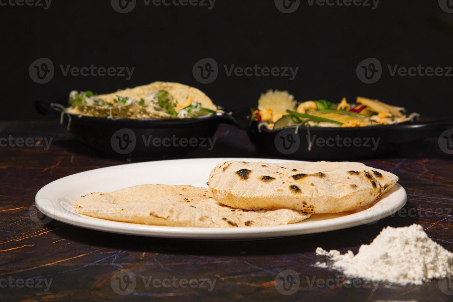 cozinha tradicional indiana chapati ou roti, ou pão indiano em chapa branca com farinha foto