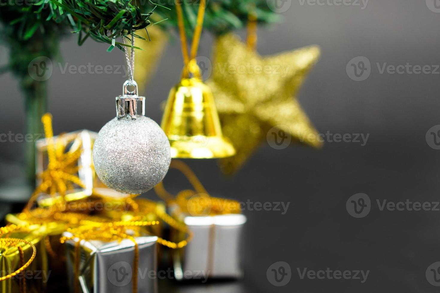 árvore de natal com item decorado pendurado em uma árvore e caixa de presente debaixo da árvore de natal. feliz natal, feliz ano novo e conceito de cartão de felicitações. foto