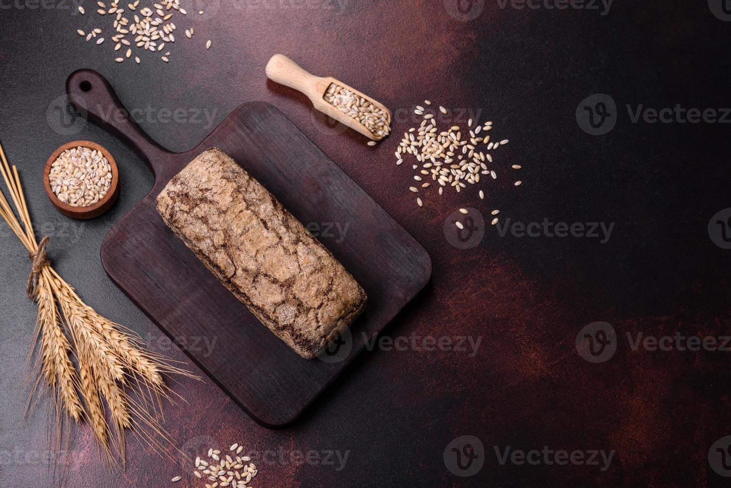 um pedaço de pão integral com grãos de cereais em uma tábua de madeira foto