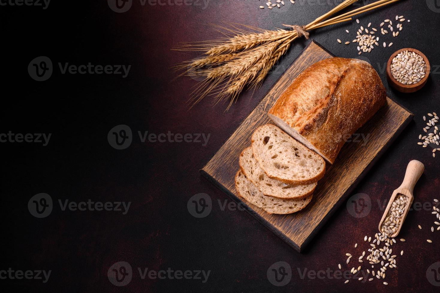 um pedaço de pão integral com grãos de cereais em uma tábua de madeira foto
