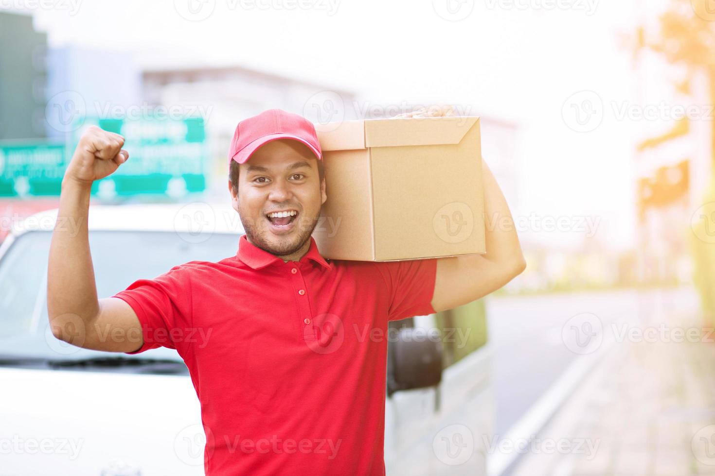 jovem feliz carregando encomendas no correio de entrega postal na entrega do pacote. foto