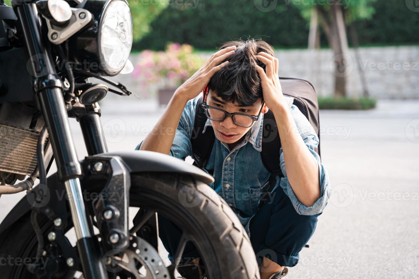 jovem asiático consertando moto foto