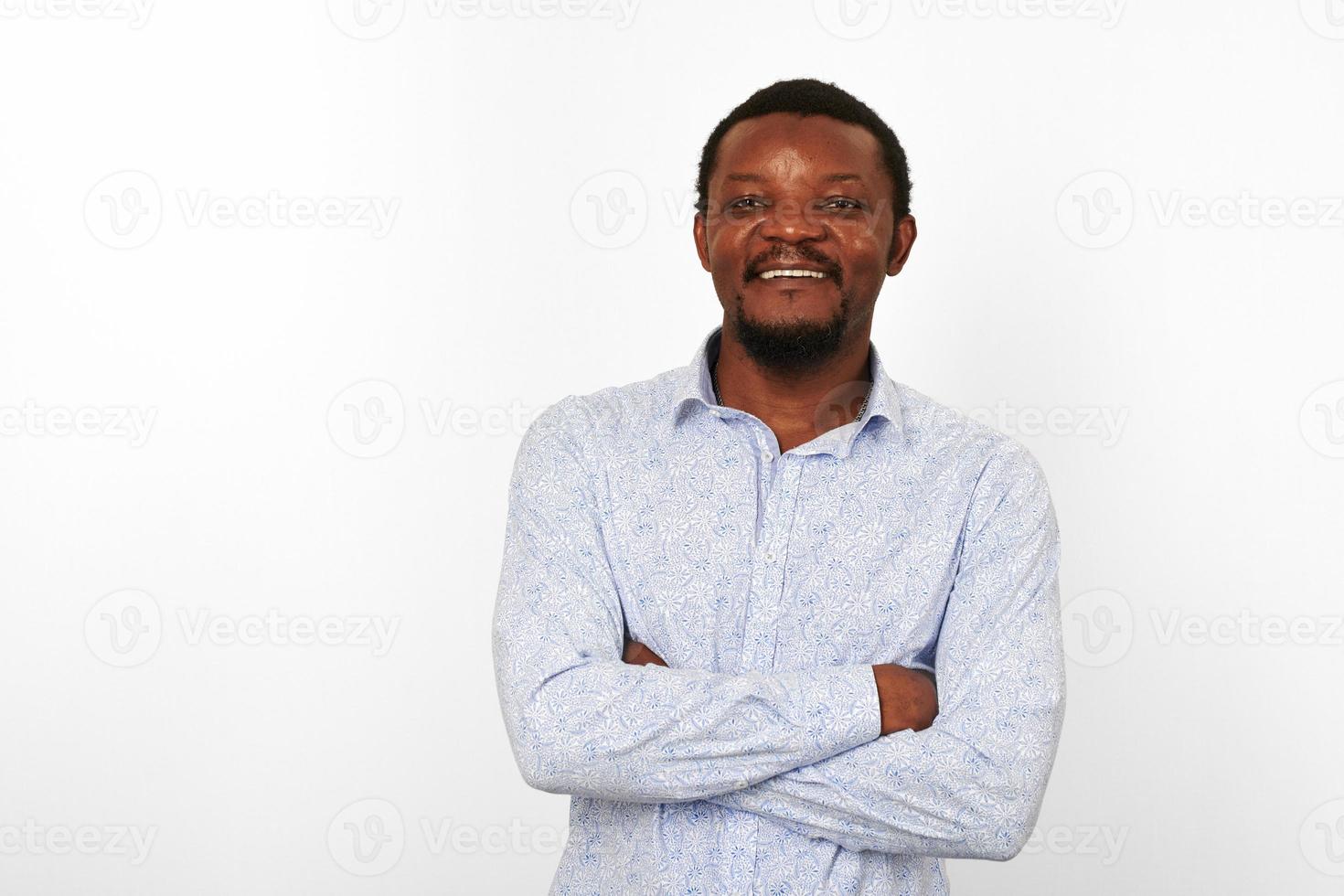 feliz homem negro afro-americano com braços cruzados em camisa brilhante casual isolado fundo branco foto