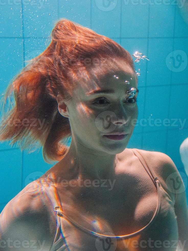 mulher de esporte atlético debaixo d'água na piscina foto