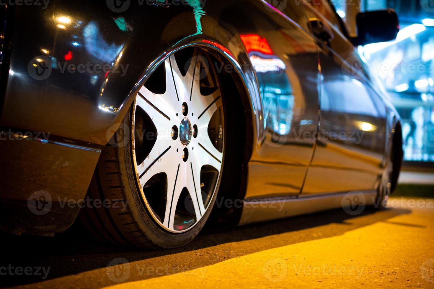 o carro está estacionado em um close-up de uma rua à noite. foto