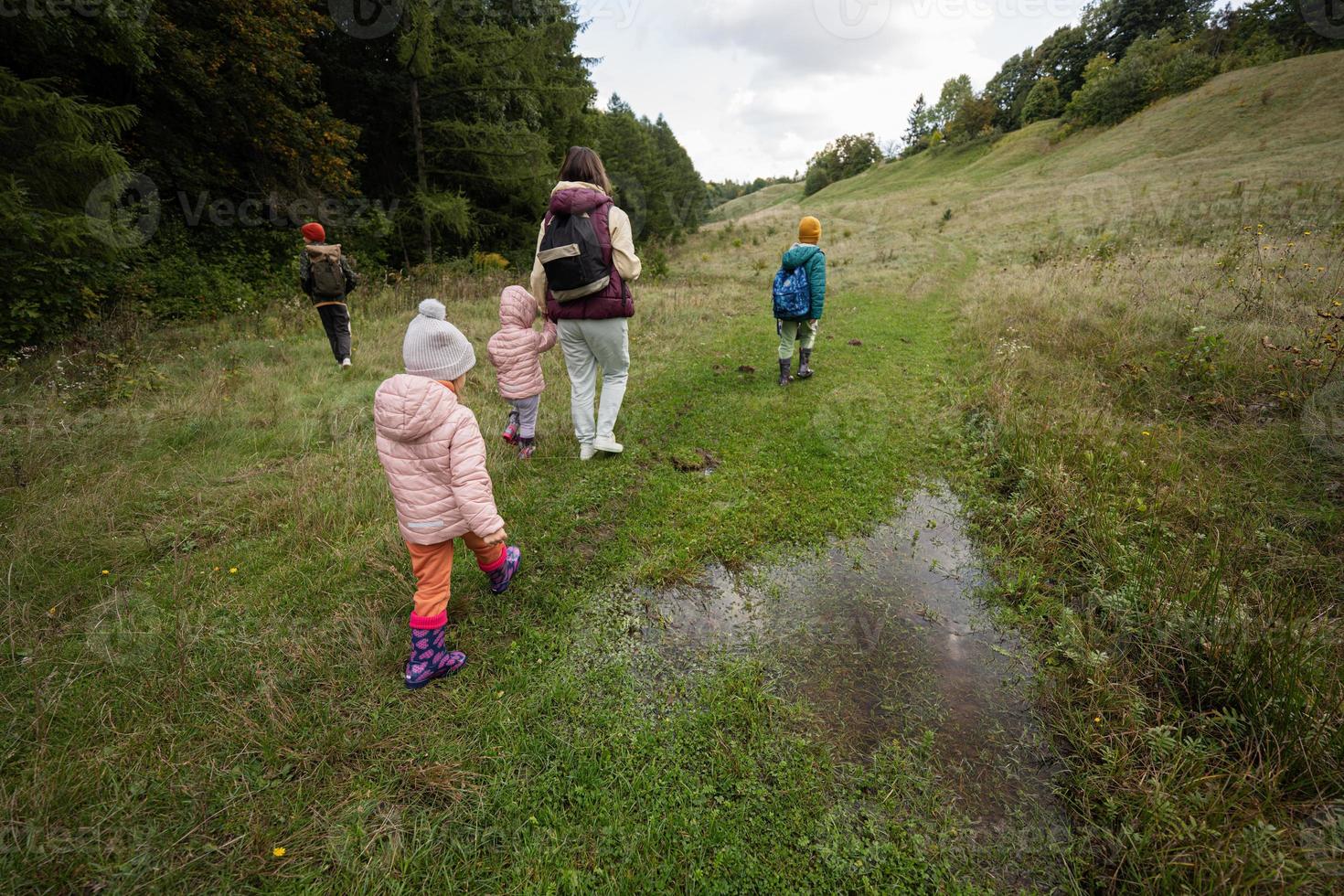 mãe e seus filhos caminhando pela floresta. foto