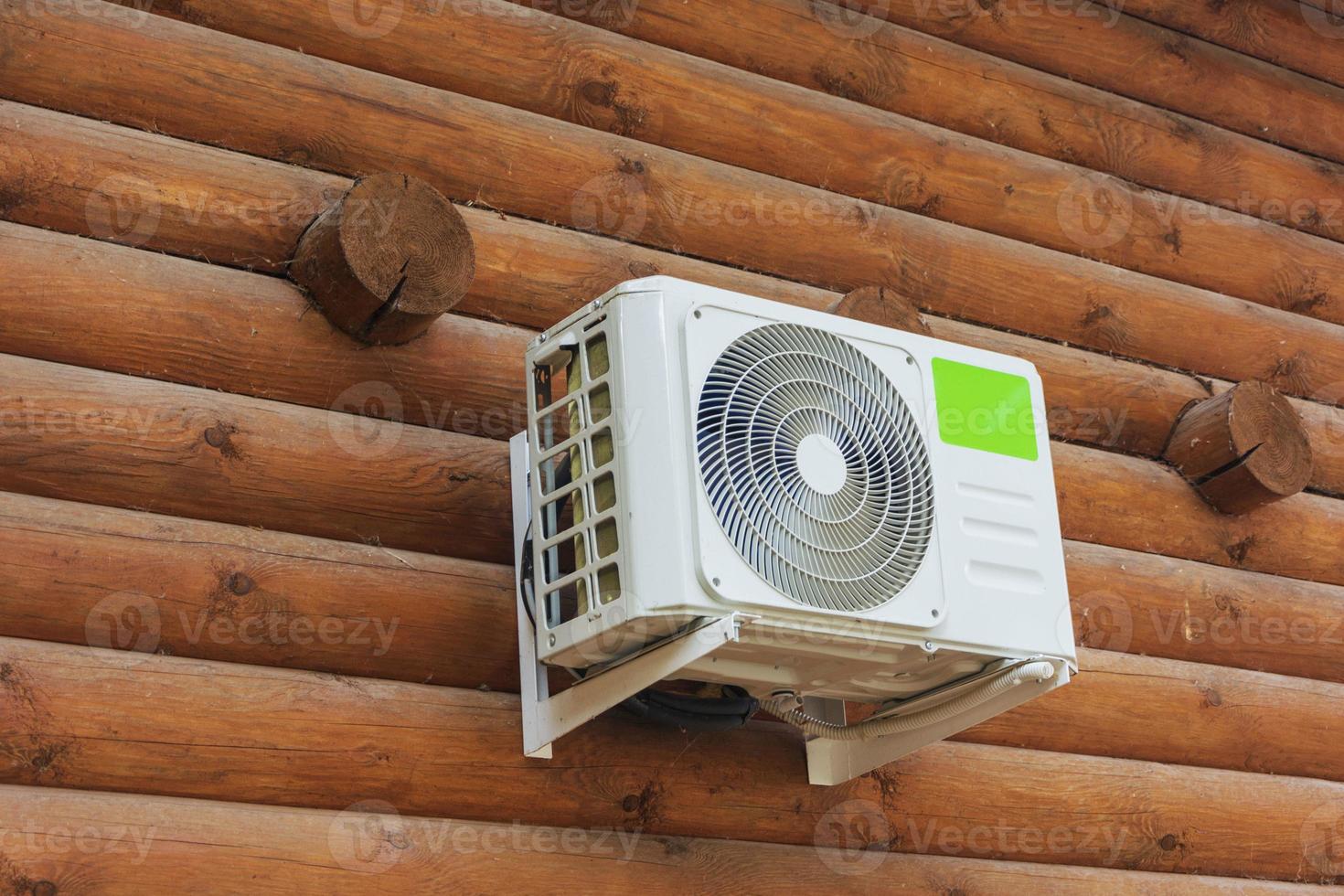 ar condicionado externo na parede de madeira de uma casa particular de toras, clima, esfria, calor, habitação confortável foto