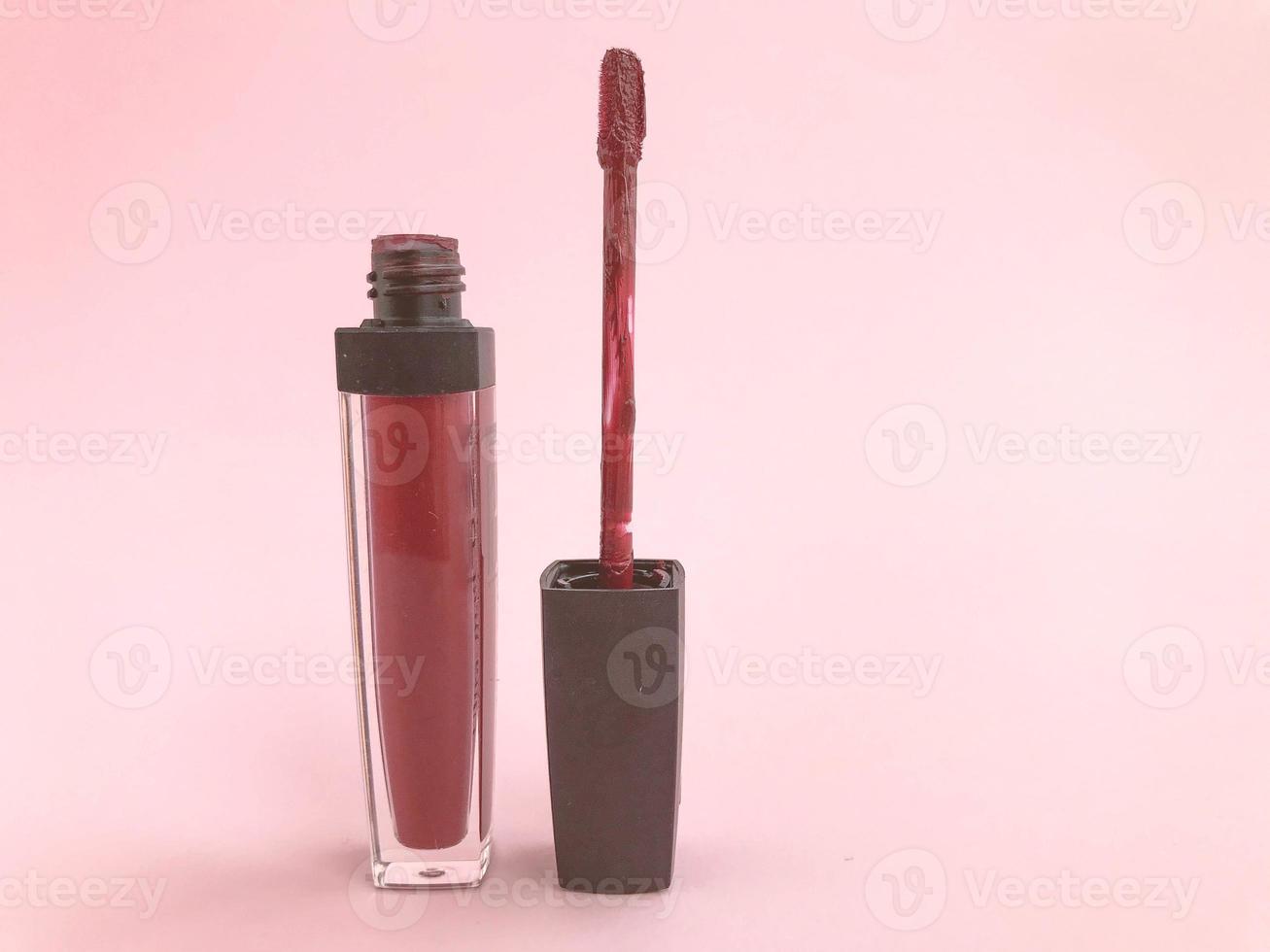 batom em um fundo fosco brilhante rosa. batom em um tom vermelho moderno e estiloso. batom com pincel macio, maquiagem labial, gloss fosco com hidratação foto