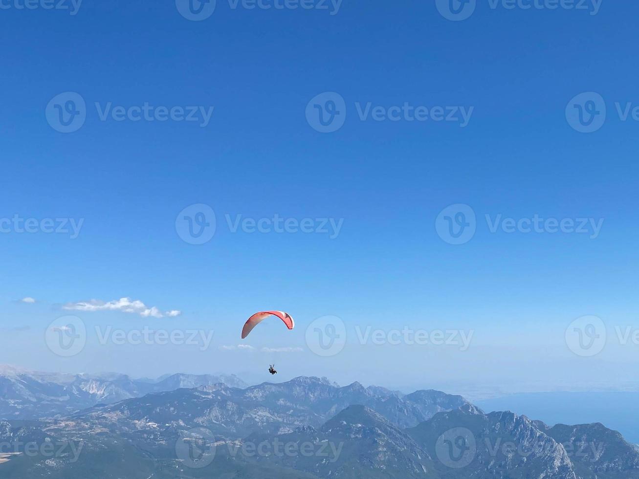 instrutor tandem de parapente amarelo com um turista voando para o céu com nuvens em um dia ensolarado foto