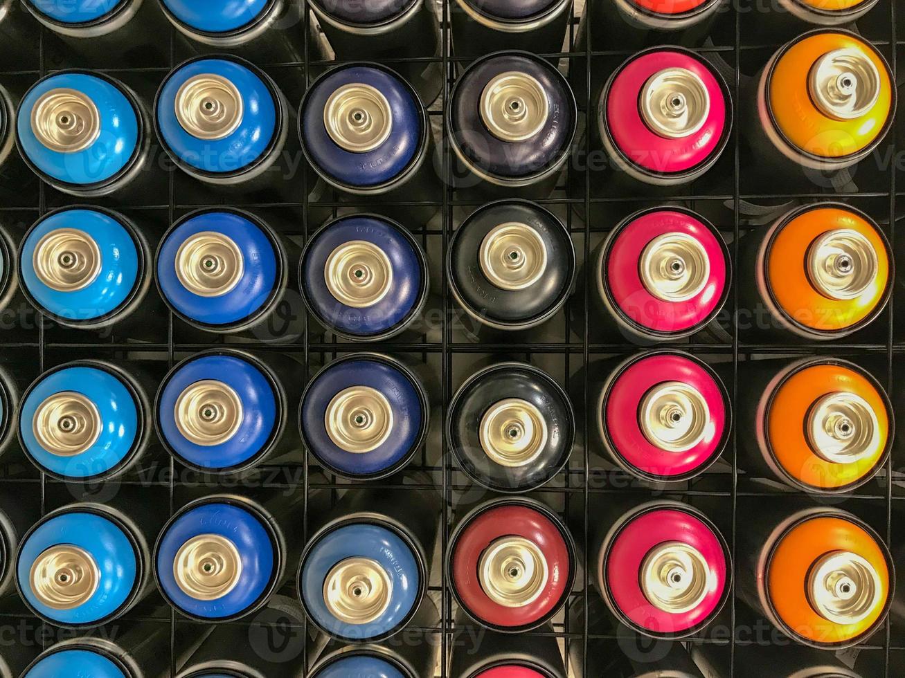 fundo colorido e texturizado de uma parede cheia de latas de tinta spray multicoloridas foto