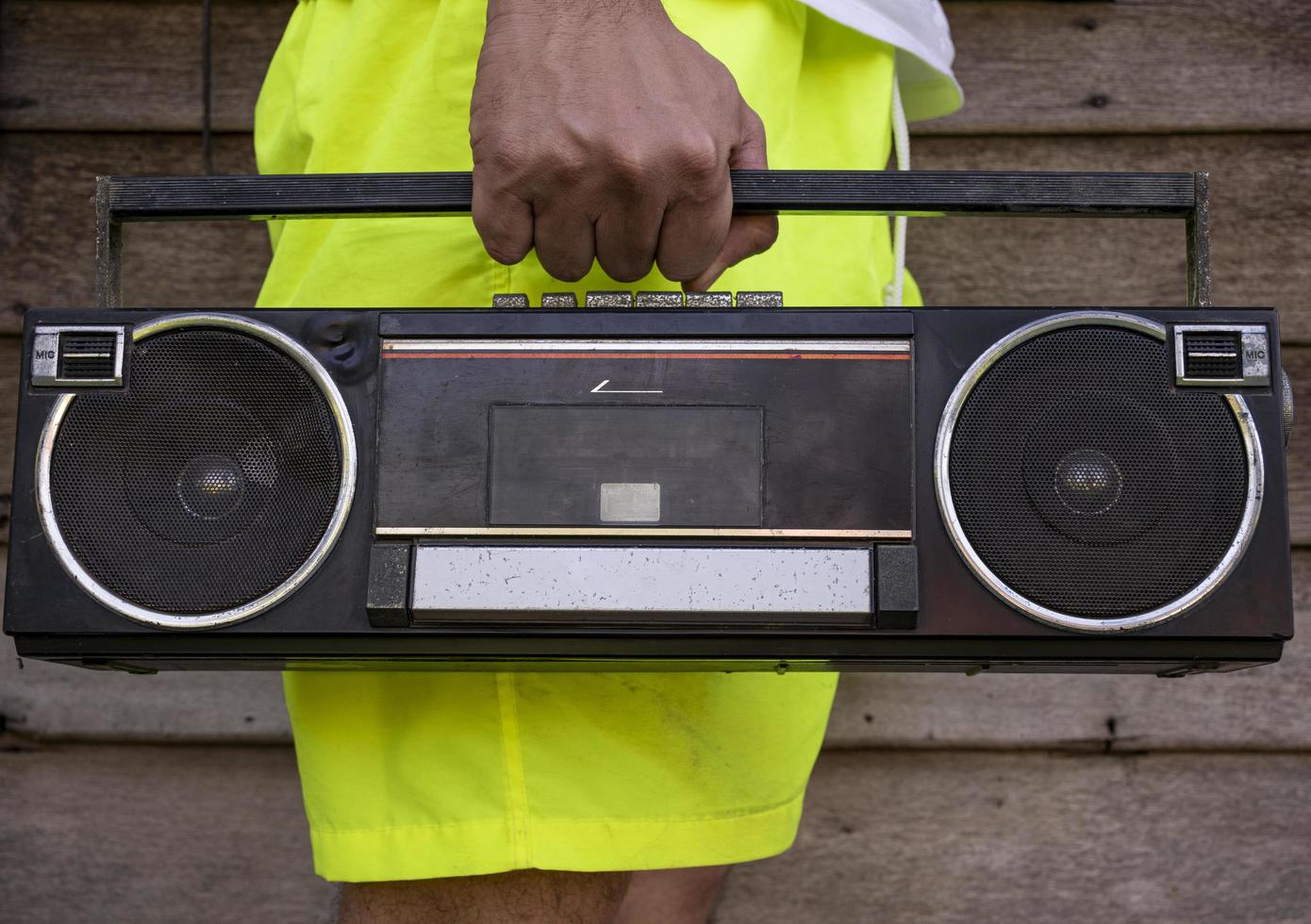 homem vestindo calça amarela segurando um rádio antigo foto