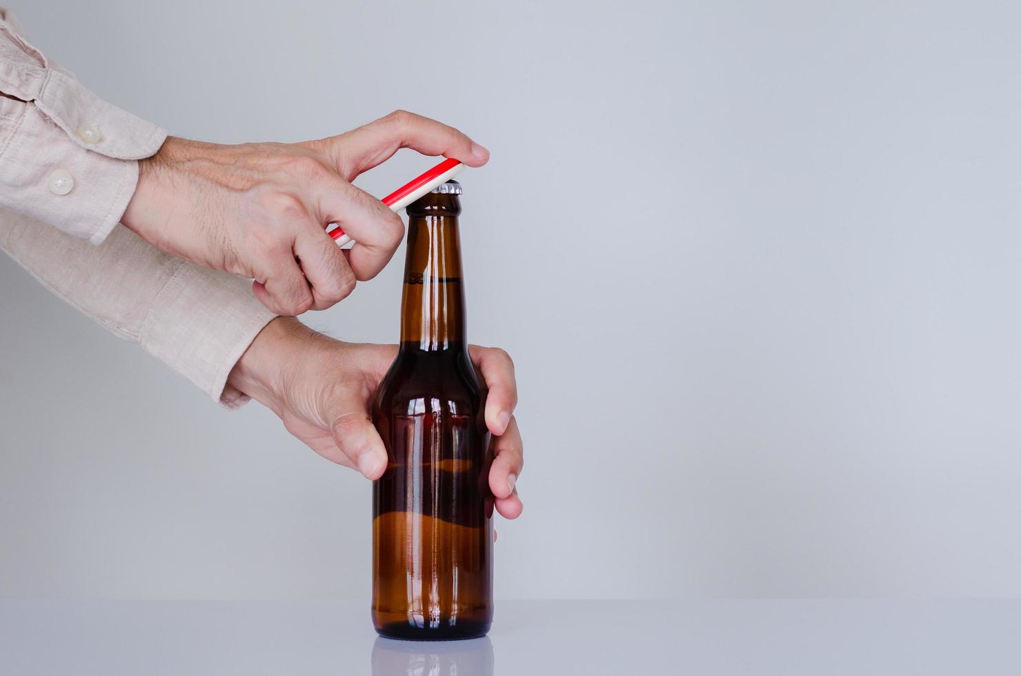 mão abrindo uma garrafa de cerveja para o conceito de dia internacional da cerveja. foto