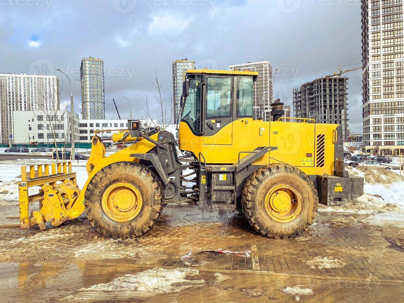 equipamentos de construção no local. construção de casas e colocação de estradas. escavadeira amarela brilhante para cavar buracos e estabelecer comunicações de encanamento foto