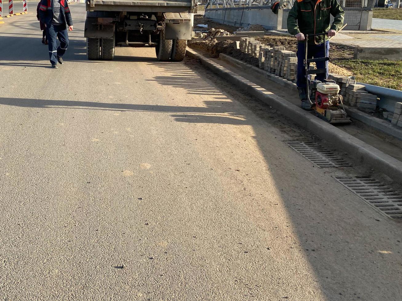 obras rodoviárias para colocação de asfalto durante a reparação da estrada por trabalhadores que usam equipamentos de construção foto