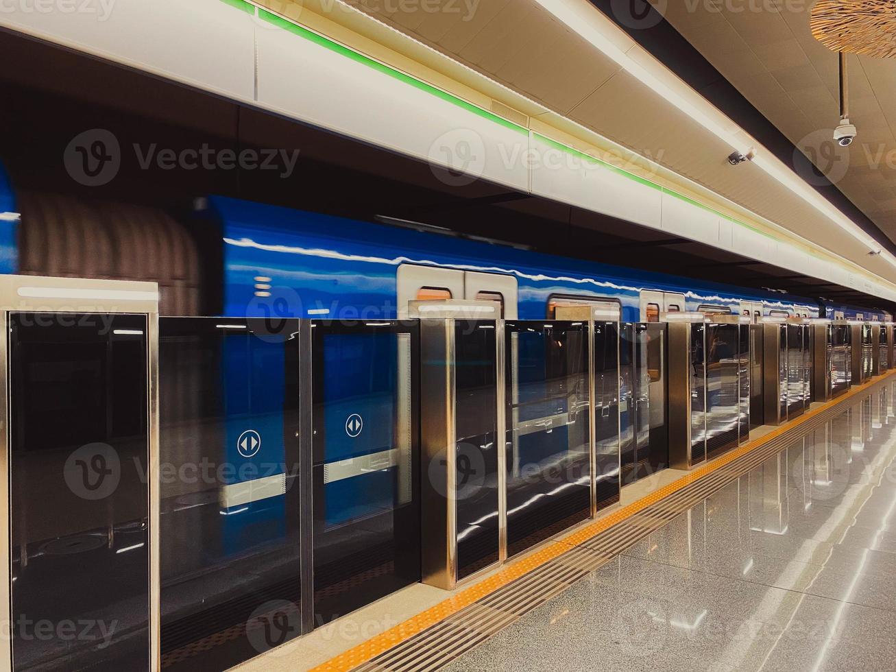 novo trem de metrô moderno azul alta velocidade rápido seguro na cidade grande na plataforma de espera na estação de metrô na estação de trem foto