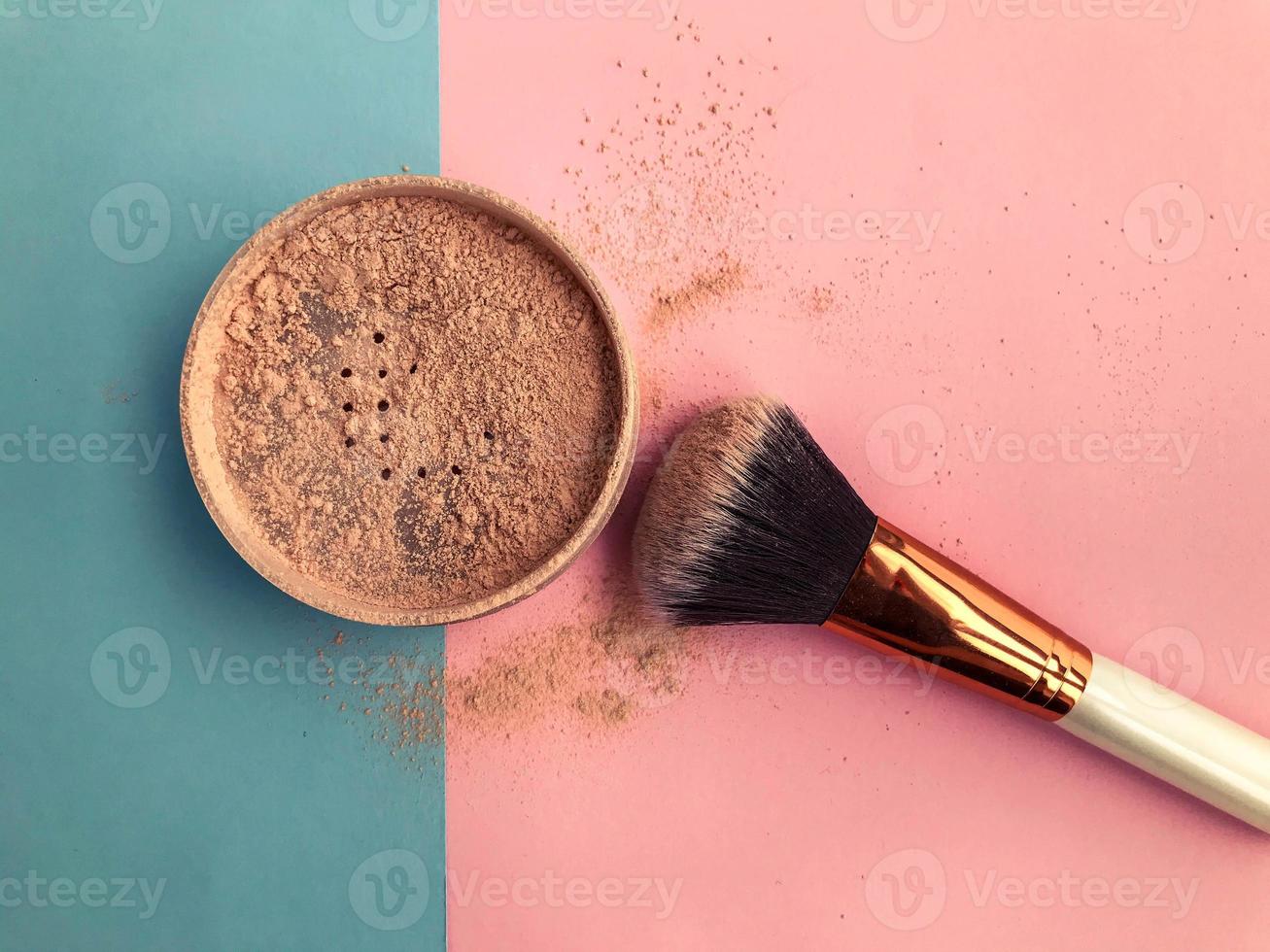 belo cosmético de beleza elegante frasco glamoroso com pó e um pincel para aplicar maquiagem no rosto em um fundo azul e rosa suave foto