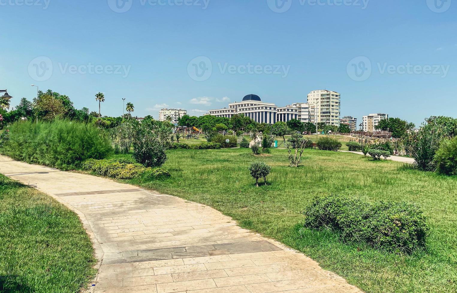 estrada no parque. ao redor estão árvores verdes, arbustos e um palácio alto de concreto. estrada de concreto pavimentada com pedras. caminhada para turistas em lugares inusitados foto