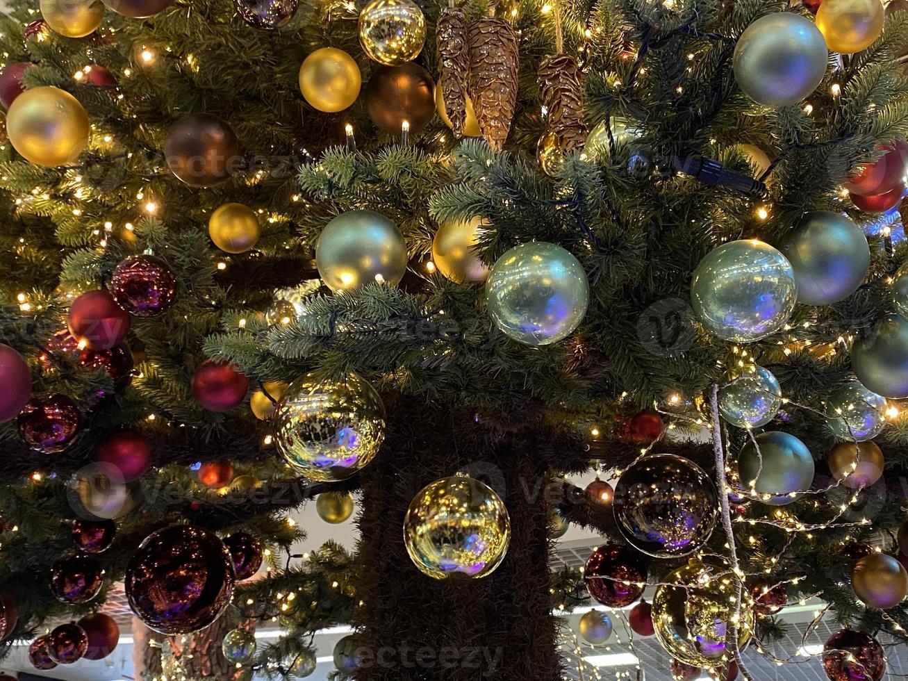 decorações de árvore de natal decoradas verdes têm ouro de caixa de bola vermelha de presente, folhas em fundo desfocado foto