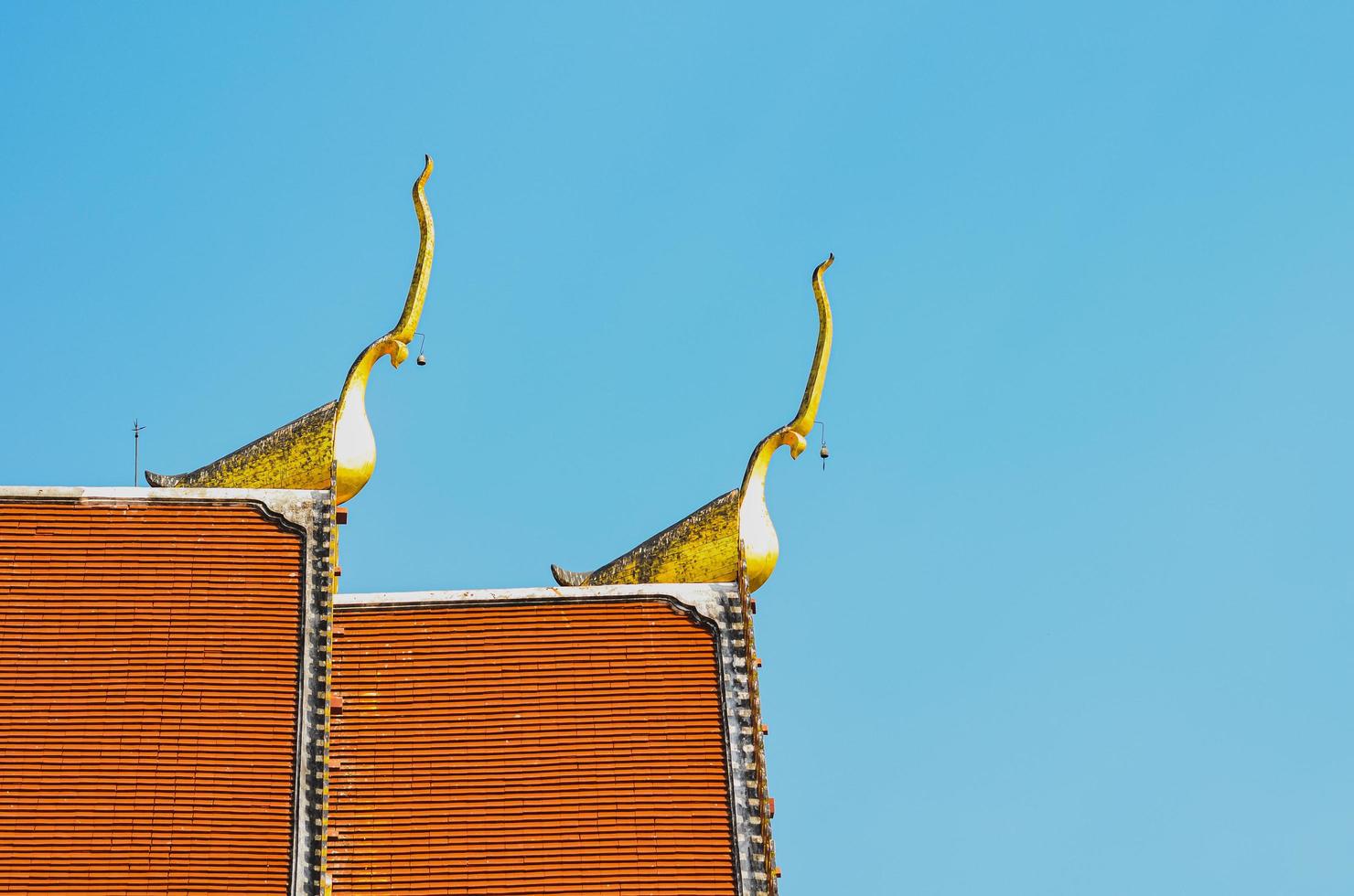 o telhado do templo de prathat cho hae com ápice de empena dourada no topo na província de phrae, tailândia, localizada na parte norte do país. foto