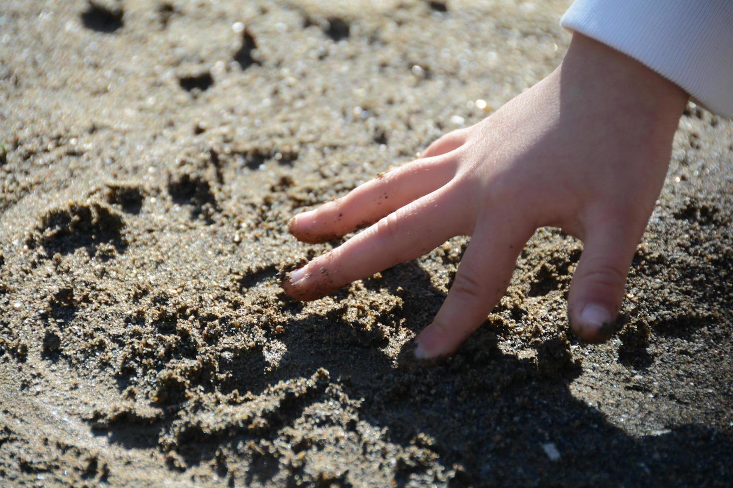 crianças dedos brincando com areia foto