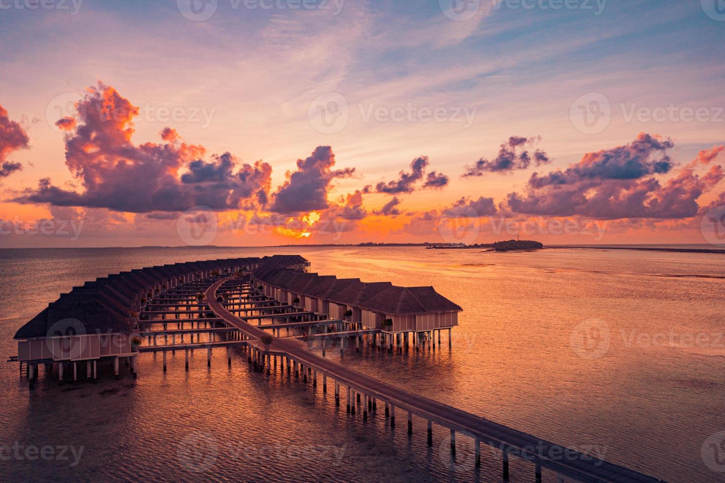 paisagem de praia incrível. bela vista do mar do pôr do sol das maldivas. horizonte colorido mar céu nuvens, sobre a água villa cais caminho. lagoa tranquila da ilha, fundo de viagens de turismo. férias exóticas foto