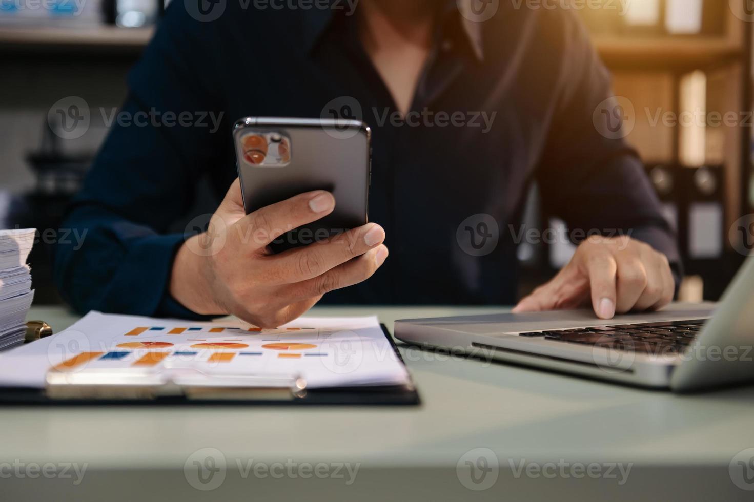 mão de empresária trabalhando mídia de marketing digital em tela virtual com telefone celular e computação moderna foto