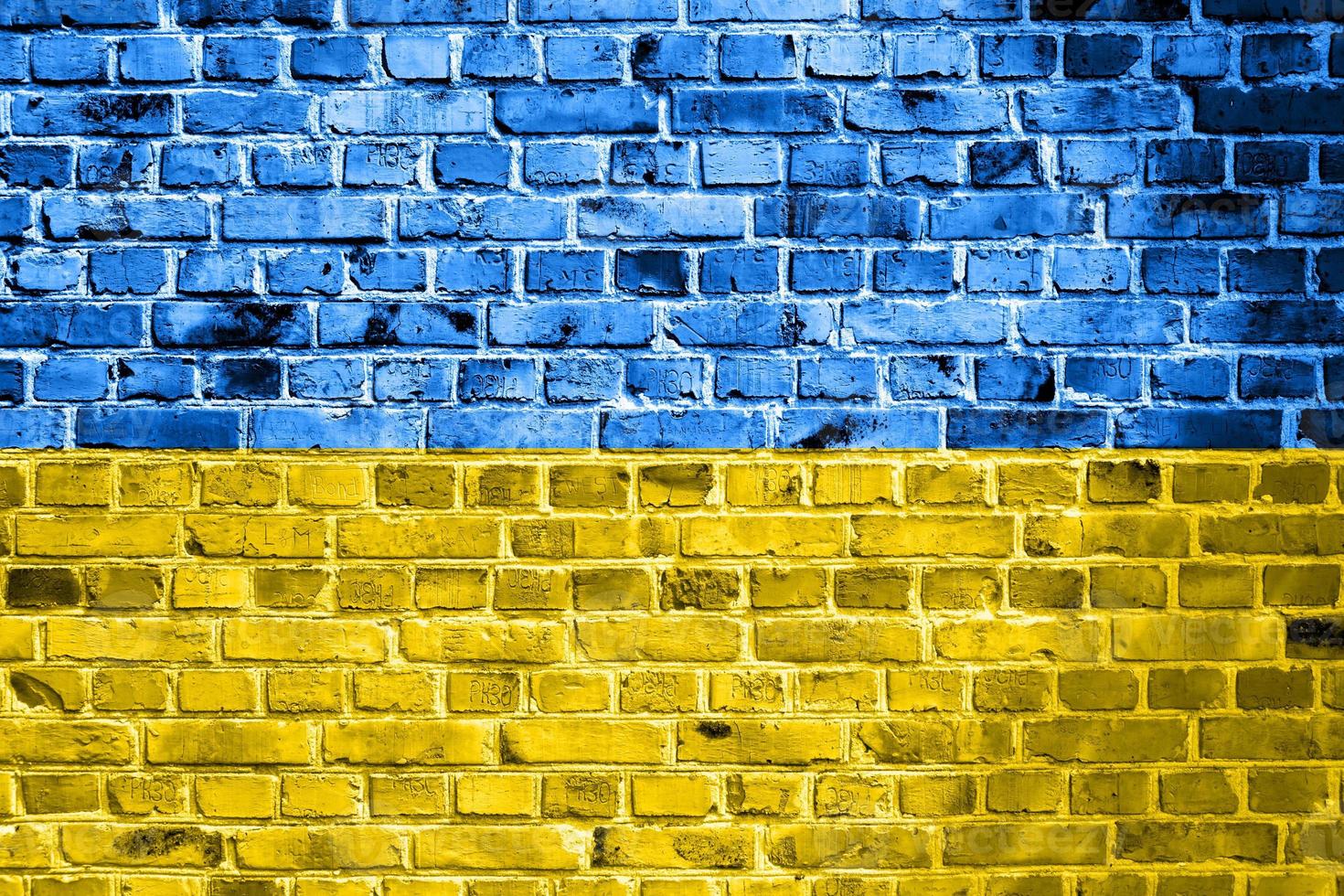 bandeira nacional da ucrânia pintada em uma parede de tijolos. banner no fundo da parede de tijolo velho em rachaduras cores azuis e amarelas. o conceito de relações entre países - sem guerra entre a ucrânia e a rússia. foto