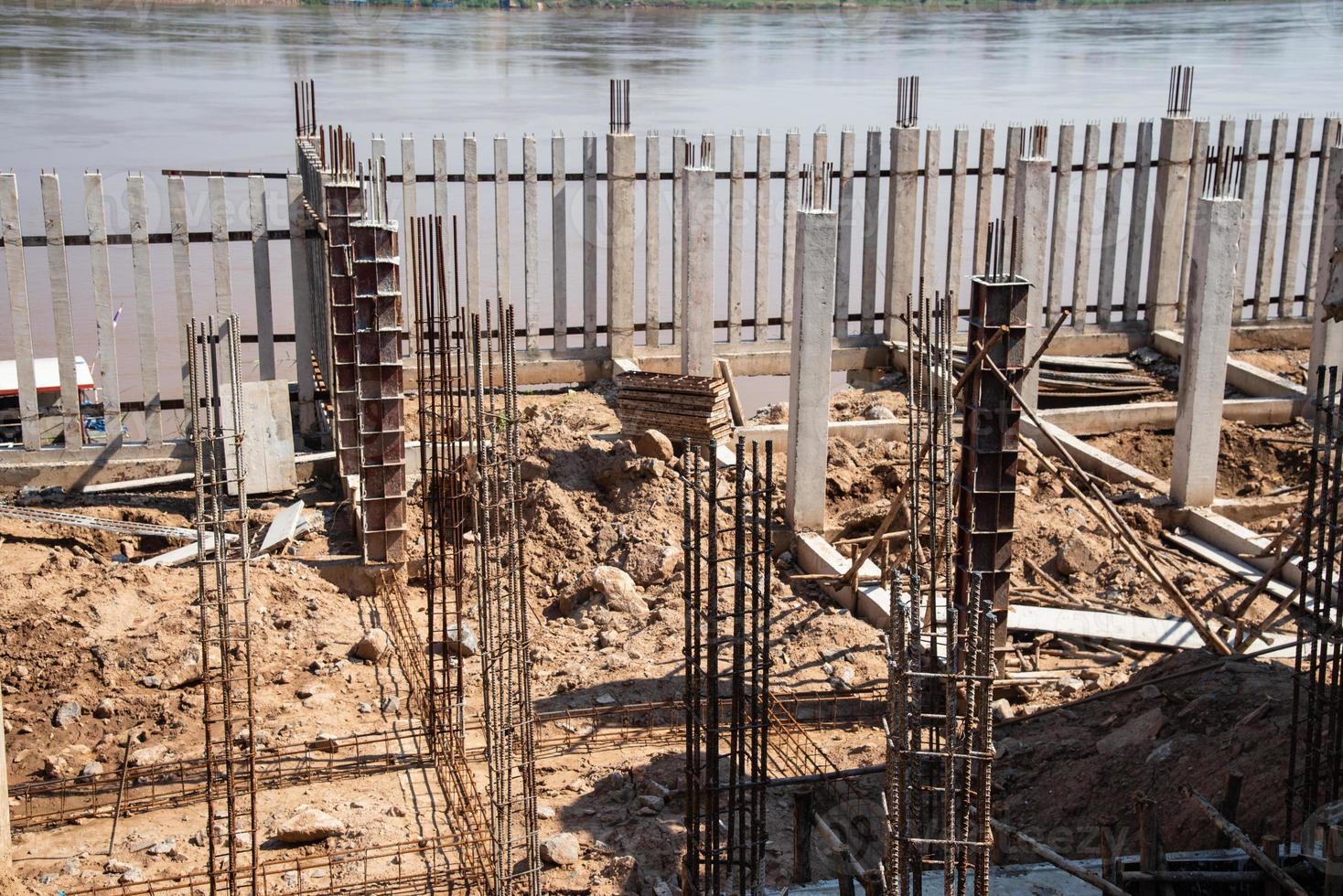 canteiro de obras com barra de aço e estacas de concreto foto