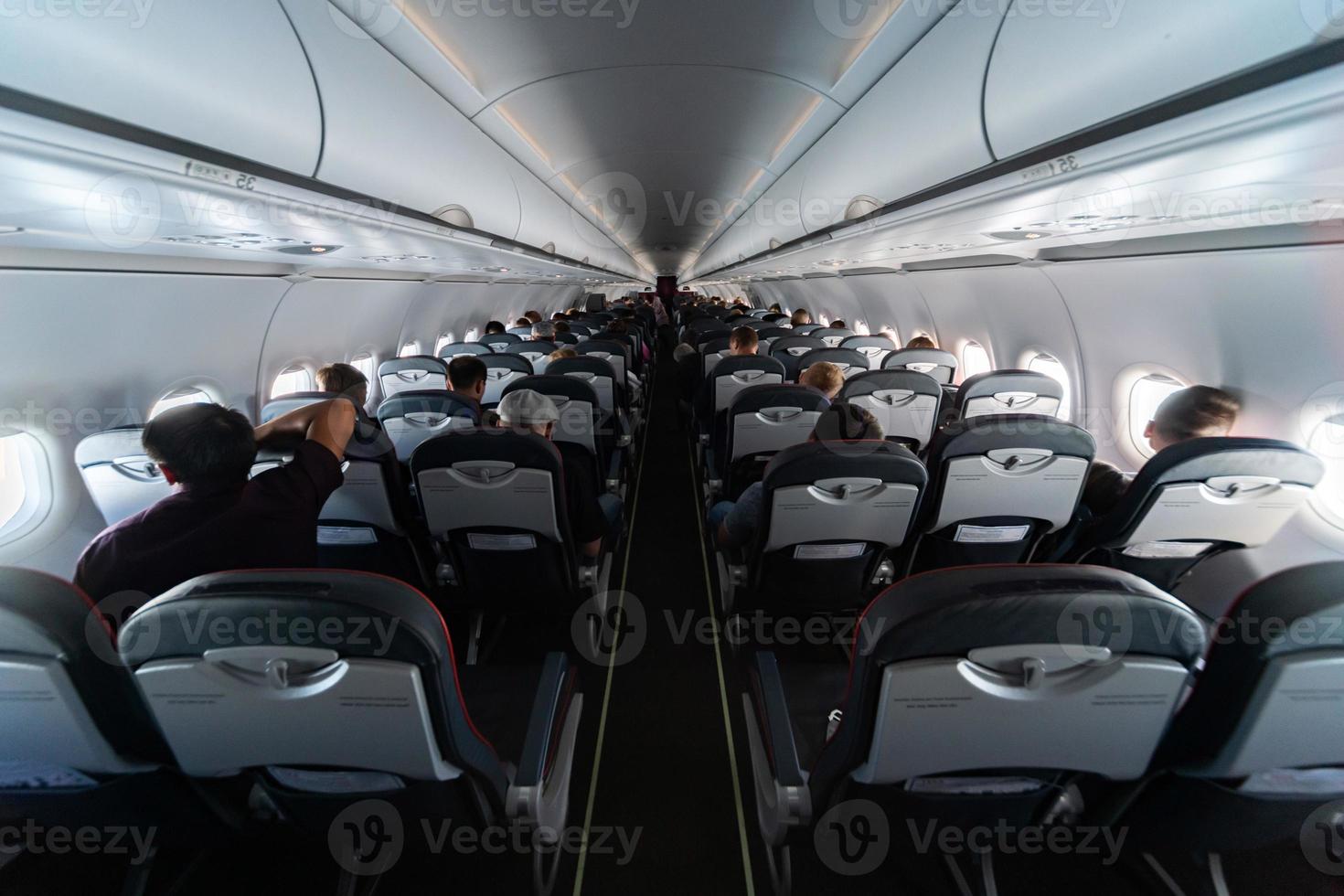 assentos de cabine de avião com passageiros. classe econômica de novas companhias aéreas de baixo custo mais baratas sem atraso ou cancelamento de voo. viagem de viagem para outro país. foto