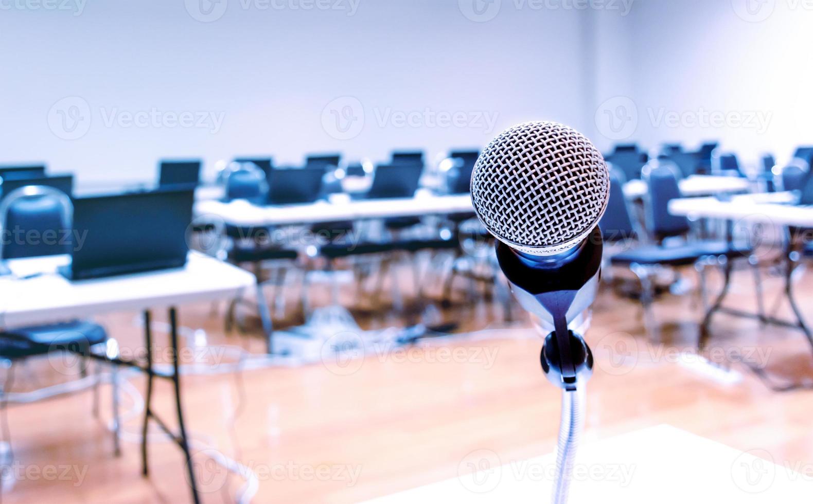 fechar o microfone com o laptop no fundo da mesa na sala de seminários foto