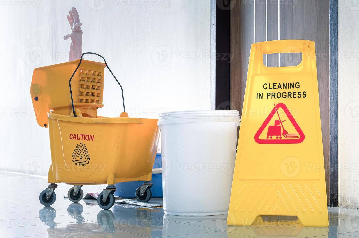 feche o sinal de aviso amarelo com limpeza de mensagem em andamento com fundo de carrinho de limpeza foto