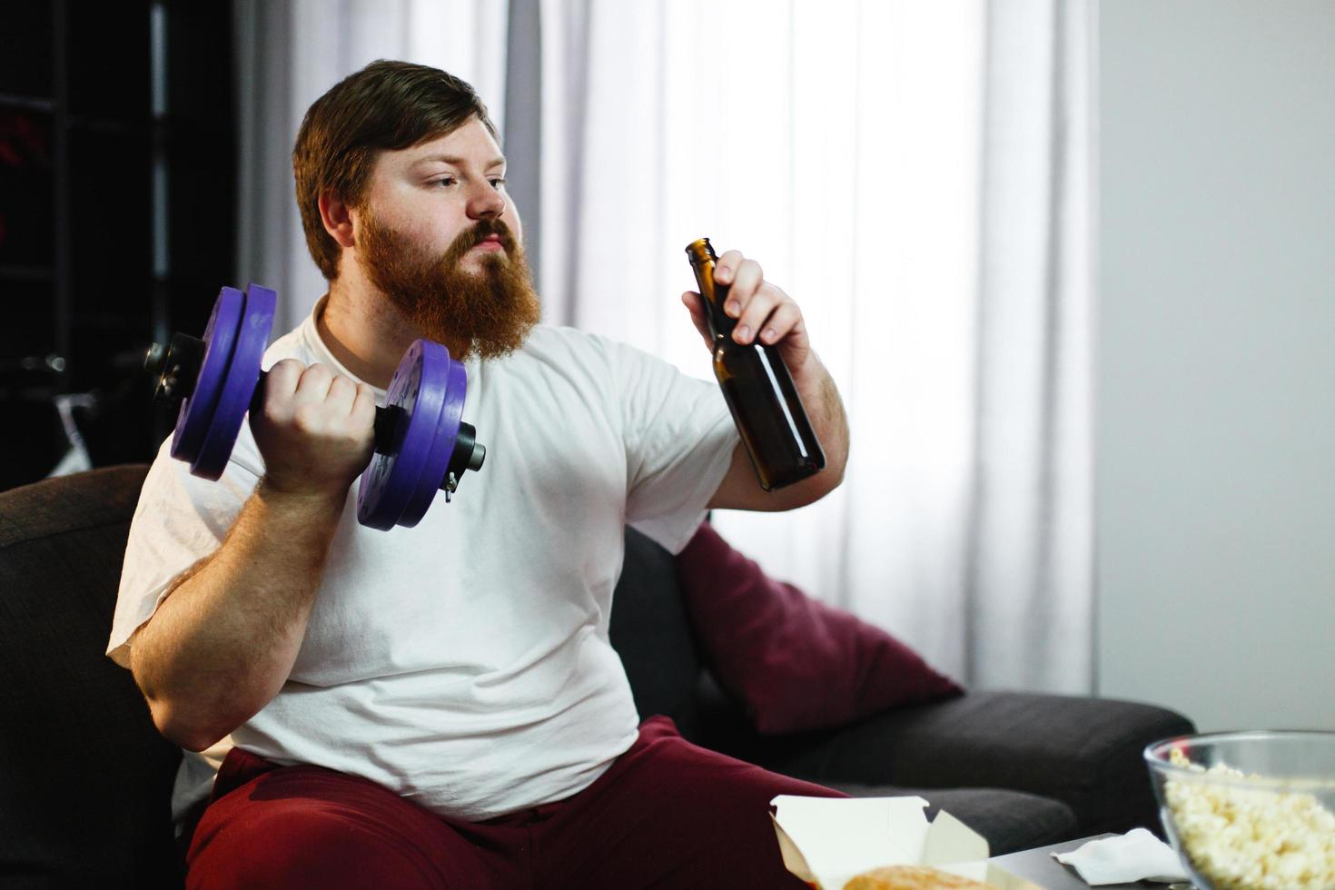 homem bebendo cerveja e levantando peso foto