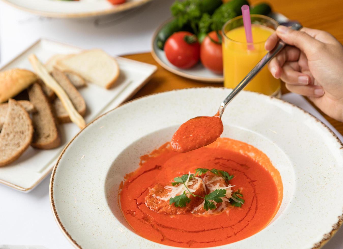 mulher comendo sopa de tomate foto